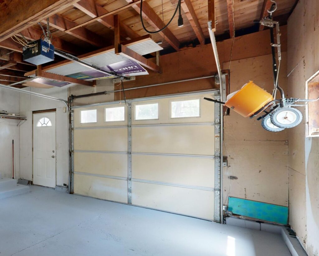 Empty garage with open space and colorful storage cabinets.